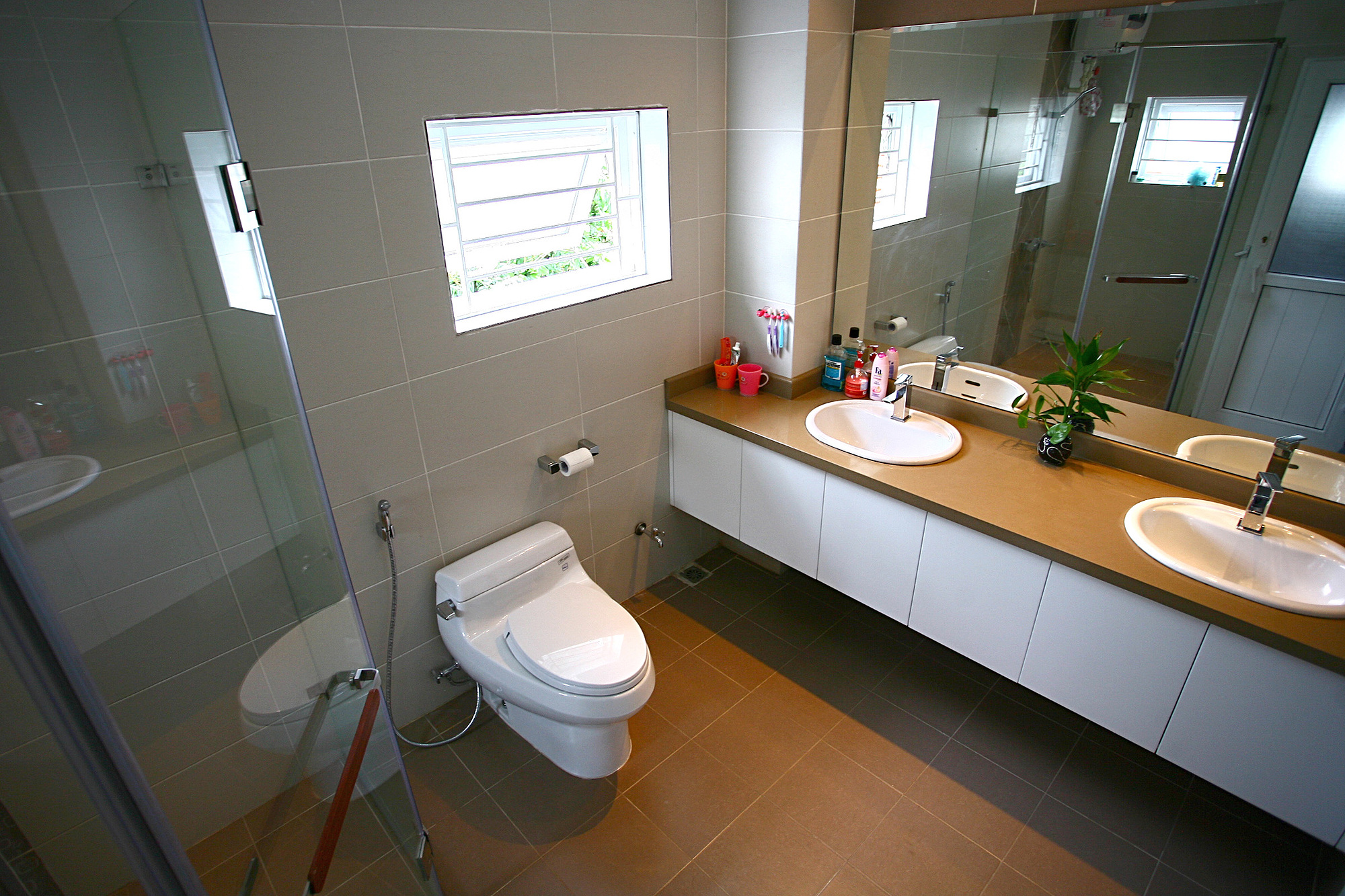 Mẫu phòng tắm này có thiết kế hiện đại, với các khu vực tắm và vệ sinh được ngăn cách nhau bởi các bức tường kính